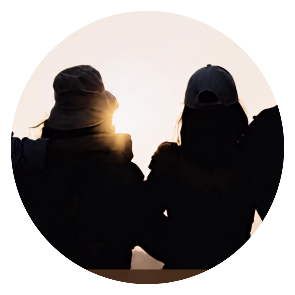 Ignite Youth Club circular photo of young people standing with arms around each other facing a sunrise